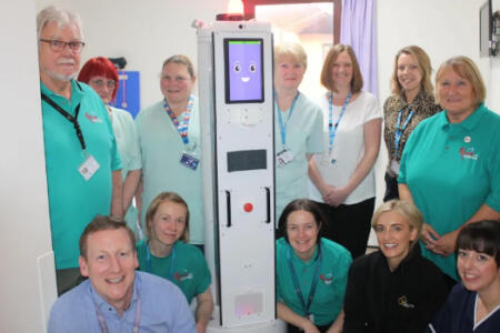 Dr James Dunbar of the Friarage Hospital and Niamh Donnelly of Akara Robotics with the robot and representatives from Friends or the Friarage and the Friarage Domestics Team